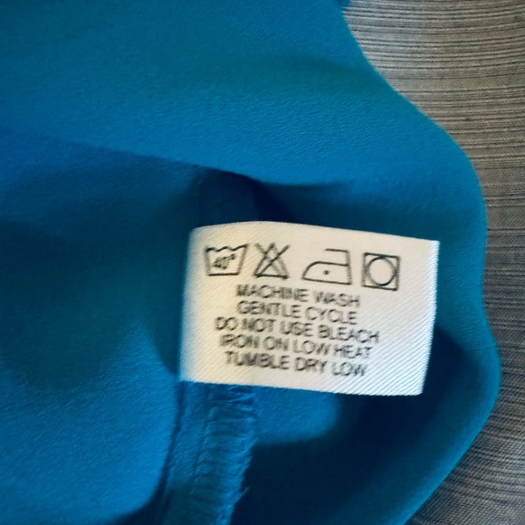 Teal blouse with teal and black highlights on a white skirt. - Picture 11 of 15